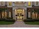 Elegant home entrance with a stone facade, manicured landscaping, and a warm, inviting glow from within at 6126 Kirkstone Ln, Windermere, FL 34786