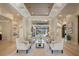 Elegant living room featuring custom ceiling, columns, light wood floors, and views of the pool at 6126 Kirkstone Ln, Windermere, FL 34786
