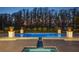 Tranquil pool illuminated at dusk, surrounded by lush landscaping and elegant stone patio at 6126 Kirkstone Ln, Windermere, FL 34786