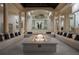 Elegant sunroom featuring a central fire pit, comfortable seating, and architectural columns at 6126 Kirkstone Ln, Windermere, FL 34786