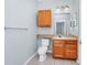 Bathroom featuring wooden vanity, white toilet, and tile flooring at 6157 Metrowest Blvd # 106, Orlando, FL 32835