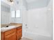 Bright bathroom with a shower-tub combo, wooden cabinets, tile flooring, and a large mirror at 6157 Metrowest Blvd # 106, Orlando, FL 32835
