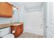 Bright bathroom featuring a shower-tub combo, wooden cabinets, tile flooring, and a light blue painted wall at 6157 Metrowest Blvd # 106, Orlando, FL 32835