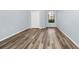 Spacious bedroom featuring wood-look flooring, a large window, and a closet at 6157 Metrowest Blvd # 106, Orlando, FL 32835