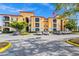 Yellow condo building with stone accents, balconies, and well-maintained landscaping provides a beautiful exterior view at 6157 Metrowest Blvd # 106, Orlando, FL 32835