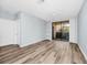 Bright living room featuring modern wood floors, neutral paint, a ceiling fan, and sliding doors to a screened balcony at 6157 Metrowest Blvd # 106, Orlando, FL 32835