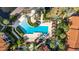 A bird's-eye view of the community pool area, featuring lounge chairs, palm trees, and lush landscaping for a relaxing environment at 6157 Metrowest Blvd # 106, Orlando, FL 32835