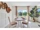 Cozy dining area features a round table, neutral decor, and a serene view of the outdoors at 7076 Painted Bunting Way, St Cloud, FL 34773