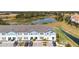 An aerial view of townhomes, green spaces, and a pond at 7509 Oak Spring Ln, Davenport, FL 33837