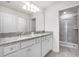 Bathroom with a double sink vanity and granite countertops, plus a glass-door shower at 7509 Oak Spring Ln, Davenport, FL 33837