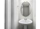 Well-lit powder room with a pedestal sink and an oval mirror at 7509 Oak Spring Ln, Davenport, FL 33837