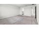 Neutral carpeted bedroom with open doorways revealing bathroom and hallway at 7509 Oak Spring Ln, Davenport, FL 33837