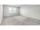 Bright bedroom with neutral carpet, white walls, and a large window at 7509 Oak Spring Ln, Davenport, FL 33837