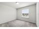 Bright bedroom with neutral carpet, a window offering natural light, and fresh white walls at 7509 Oak Spring Ln, Davenport, FL 33837