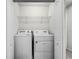 Close-up of the in-unit laundry closet, complete with appliances and upper shelving for convenience at 7509 Oak Spring Ln, Davenport, FL 33837