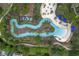 Aerial view of a community lazy river winding through a lush landscape with palm trees and seating areas at 7509 Oak Spring Ln, Davenport, FL 33837