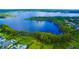Lush aerial view showing a beautiful home and green space on a deep blue lake at 8424 Lake Burden Cir, Windermere, FL 34786