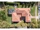 Aerial view of a tile roofed house, screened pool, brick driveway and outdoor firepit at 8424 Lake Burden Cir, Windermere, FL 34786