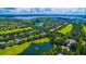 Beautiful aerial view of a community with golf course, lake, lush greenery, and stunning blue sky at 8424 Lake Burden Cir, Windermere, FL 34786