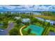 Aerial view of community with clubhouse, pool, sport court, lake, and lush landscaping at 8424 Lake Burden Cir, Windermere, FL 34786