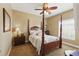 This cozy bedroom features a four-poster bed, ceiling fan, and neutral decor at 8424 Lake Burden Cir, Windermere, FL 34786