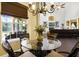 Bright breakfast nook with round glass table, stylish seating and view into the living room at 8424 Lake Burden Cir, Windermere, FL 34786