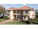 Side view of tan two-story home with tile roof, balcony, and beautiful landscaping at 8424 Lake Burden Cir, Windermere, FL 34786