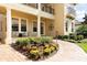 Inviting two-story home featuring a landscaped yard, covered porch with decorative columns and a brick walkway at 8424 Lake Burden Cir, Windermere, FL 34786