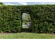 View of the firepit through an arched doorway in a tall, manicured garden hedge at 8424 Lake Burden Cir, Windermere, FL 34786