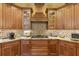 Close up of gourmet kitchen with custom cabinets, granite countertops, and gas cooktop at 8424 Lake Burden Cir, Windermere, FL 34786