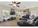 Spacious living room featuring a ceiling fan, a large sectional sofa, and a wall of entertainment decor at 8424 Lake Burden Cir, Windermere, FL 34786