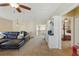 Living room with black leather couch, ceiling fan, study nook, and doorway to the main bedroom at 8424 Lake Burden Cir, Windermere, FL 34786