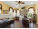 Office space with multiple windows, ceiling fan, dark wood floors, built-in bookshelf, and zebra chair at 8424 Lake Burden Cir, Windermere, FL 34786