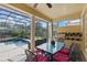 Poolside outdoor patio with pillars, a ceiling fan, outdoor kitchen, and a glass-top table with seating overlooking the screened-in pool at 8424 Lake Burden Cir, Windermere, FL 34786