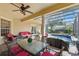 Poolside outdoor patio with pillars, a ceiling fan, and a glass-top table with seating overlooking the screened-in pool and yard at 8424 Lake Burden Cir, Windermere, FL 34786