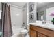 Cozy bathroom with tub-shower combo, framed artwork, and a wood vanity with countertop sink at 8961 Cuban Palm Rd, Kissimmee, FL 34747