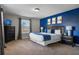 Modern bedroom featuring a king bed, a blue accent wall, and stylish nightstands with lamps at 8961 Cuban Palm Rd, Kissimmee, FL 34747