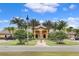View of the clubhouse exterior, showcasing its well-maintained landscaping, architectural details, and circular driveway at 8961 Cuban Palm Rd, Kissimmee, FL 34747