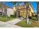 Charming two-story yellow home with well maintained landscape and driveway at 8961 Cuban Palm Rd, Kissimmee, FL 34747