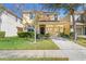 Inviting two-story home with a well-manicured lawn, lush landscaping, and an attached single-car garage at 8961 Cuban Palm Rd, Kissimmee, FL 34747