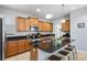 Kitchen featuring wooden cabinets, granite countertops, a central island with bar stool seating, and modern appliances at 8961 Cuban Palm Rd, Kissimmee, FL 34747