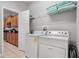 Functional laundry room equipped with a washer, dryer, and ample storage shelving at 8961 Cuban Palm Rd, Kissimmee, FL 34747