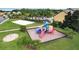 Community playground with play structure, sandbox, and adjacent sand volleyball court on lush green grass at 8961 Cuban Palm Rd, Kissimmee, FL 34747