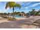 Relaxing view of the pool area, featuring lounge chairs, tables, umbrellas, and a scenic waterfall feature at 8961 Cuban Palm Rd, Kissimmee, FL 34747