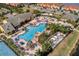 Aerial view of the community pool, complete with lounge chairs, umbrellas, palm trees, and a dining area at 8961 Cuban Palm Rd, Kissimmee, FL 34747