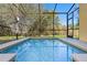 Screened-in pool offers a private oasis for relaxation and recreation with views of the lush backyard at 8961 Cuban Palm Rd, Kissimmee, FL 34747