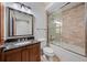 Bathroom with granite-topped vanity and tiled shower-over-tub featuring sliding glass door at 900 S Lake Adair Blvd, Orlando, FL 32804