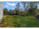 Expansive, well-maintained backyard with lush green grass, mature trees, and a classic black metal fence at 9192 Bradleigh Dr, Winter Garden, FL 34787