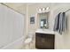 Well-lit bathroom featuring a bathtub with shower, toilet, vanity with sink, and a decorative framed Maine print at 9192 Bradleigh Dr, Winter Garden, FL 34787