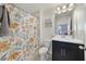 A clean bathroom with floral curtain shower, dark vanity and a painting on the wall at 9192 Bradleigh Dr, Winter Garden, FL 34787